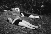 Två kvinnor ligger och solar, troligtvis vid Tulebosjön cirka 1930.