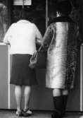 Två kvinnor i färd med att handla. Troligtvis i Mölndal på 1960-talet.