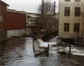 Vy västerut från Rackarebron över Mölndalsfallen, 1970-tal. Till vänster ses ett gammalt magasin från 1800-talet och till höger byggnaden 