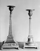 Två ljusstakar i metall varav den vänstra är något högre. Gunnebo slott, 1930-tal.