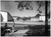 Fredhälls folkskola, (HLS)
Exteriör, människor och barnvagn i förgrunden