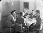 Sex personer äter mat kring ett bord
Interiör