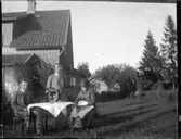 Vid ett bord i trädgården. Troligen i aug, 1931. Mamma, Anders och jag.