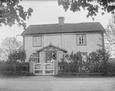 Par vid grinden framför ett hus