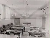 Skolsal med bord och stolar. Interiör från Falkenbergs kommunala mellanskola.
