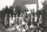 Lärare och elever i gräset framför på Mosjö kyrkskola, höstterminen 1932