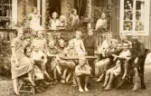 Skolklass sittande i utemöbler framför Alltorps skola, 1920-tal