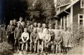 Skolklass sittande på långbänk vid Alltorps skola, 1930-tal