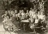 Skolklass sitter i trädgårdsmöblerna utanför Alltorps skola, 1950-tal