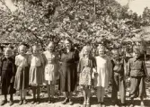 Elever med lärarinna framför blommande träd vid Alltorps skola, 1930-tal