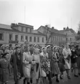 Andra dagens studenter, 1944.
Studenter med anhöriga på väg utmed Stortorget. I bakgrunden syns en del av husen längs Kronobergsgatan.