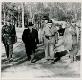 Några herrar vandrar längs en grusväg. I mitten landshövding Thorwald Bergquist och kommissarie Sture Sandell. De övriga okända.
Spaning efter 