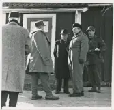 Samling vid ett bostadshus på landet. I mitten landshövding Thorwald Bergquist och t.h. kommissarie Sture Sandell. De övriga okända.
Spaning efter 