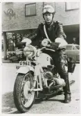 Börje Skoog vid statspolisen, Växjö, har grenslat sin motorcykel på Oxtorget, 1958.