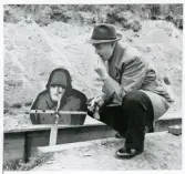 Poliskonstapel Berne Strömqvist hukar vid en måltavla på en skjutbana, ca 1959.