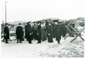 Rinkaby utanför Kristianstad. Fångläger för balter m.fl., januari 1946.
Polisvakt i väntan inför förflyttning av fångarna med buss till Trelleborg och deportation.