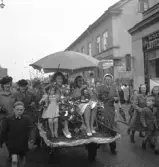 Andra dagens studenter, 1944.
Två kvinnliga student körs iväg längs Storgatan, från Stortorget. Till höger skymtar butiken Lindgren & Brandt.