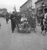 Tredje dagens studenter, 1944.
En kvinnlig student körs iväg längs Storgatan av sina kamrater. Till höger syns bl.a. Lindgren & Brandts affär.