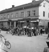 Tredje dagens studenter, 1944.
En student bärs iväg på en järnsäng längs Storgatan, av sina kamrater. I bakgrunden syns dåv. P.N. Perssons fastighet med Wigéns och skoaffären Oscaria.