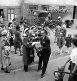 Tredje dagens studenter, 1944.
En kvinnlig student bärs in från gatan, av sina kamrater. I bakgrunden
skymtar ett bostadshus m.m.

Angående avgångsklassen 1944 - se 