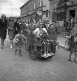 Studentfinal, 1944. 
En kvinnlig student körs iväg på cykelkärra längs Storgatan, av sina kamrater. I bakgrunden syns P.N. Perssons fastighet och 