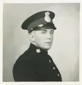 En okänd poliskonstapel, Kronobergs län, ca 1935-40.
Bröstbild, halvprofil. Ateljéfoto.