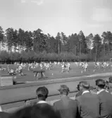 Gymnastiken 1944.
Gymnastikuppvisning (truppgymnastik) av yngre, manliga gymnaster. 
Fotot taget från publikläktaren.