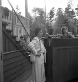 Gymnastiken 1944.
En kvinnlig ledare i vit dräkt ser på, under gymnastiken.