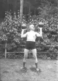 Kraftkarl poserande med hanteltyngder för atletklubben Heros i Valbo tidigt 1900-tal.