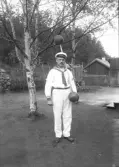 Man ifrån atletklubben Heros klädd i sjömansdräkt poserar med kulhantel tidigt 1900-tal.