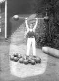 Kraftkarl ifrån atletklubben Heros utför ett tyngdlyft med vikstång, tidigt 1900-tal.