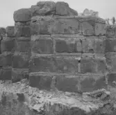 Gudsberga kloster, Husby socken. Pelarbas i kyrkans mitt mot den norra mren. Pelaren är uppmurad i tegel med en klack av gråsten som sträcker sig västerut.