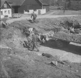 Gudsberga kloster, Husby socken. Undersökningsarbete vid den norra muren intill korpartiet. På murens utsida arbetade två man med borttagande av stora grabstubbar,