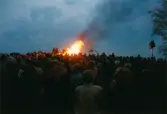 Firande på Störtfjället i Mölndal under valborgsmässoaftonen den 30 april 1998. Människor har samlats kring valborgsmässoelden.