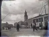 Vy över Stora Hamnkanalen med Södra och Norra Hamngatorna. I bakgrunden syns Kristine kyrka. 
En spårvagn har just stannat till.