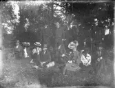 Foto av några människor som slagit sig ner i en skogsglänta.