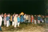 Firande på Störtfjället i Mölndal under valborgsmässoaftonen den 30 april 1998. Människor har samlats vid valborgsmässoelden.