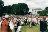 Midsommarfirande vid Gunnebo slott i Mölndal, okänt årtal. Dans kring midsommarstången. Slottet i bakgrunden.