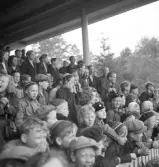 Folkskolans tävlingar, 1944.
Många barn på hedersläktaren hejar på sina tävlande.