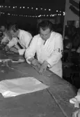 Hantverkstävling på Rotundan den 2 april 1950. Skräddare vid tillskärning.