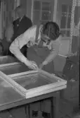 Hantverkstävling på Rotundan den 2 april 1950. En målare vid ett fönster.