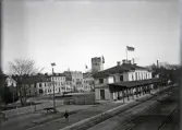 Järnvägsstationen i Växjö, trol. en tidig morgon. Flaggan (med unionsmärke) är hissad. Bakom stationen syns husen vid Norra Järnvägsgatan  (kvart. Linné) och domkyrkans torn.