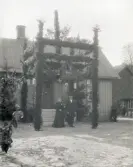 Bröllopsfirande, med en stor äreport framför husets entré