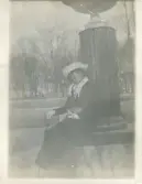 Foto av Anna-Lisa Algren sittande vid en staty (enligt text skriven i albumet).