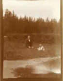 Foto av pappa och barnet på Taberg som sitter i gräset (enligt text skriven i albumet).