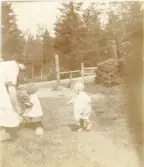 Foto av Tora gråtande till moster Tora, barnet Lill-Inga har agat sin kusin. Inga är där ett år och några månader (enligt text skriven i albumet).