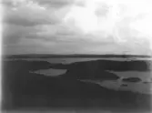 Vy över skärgården i norra Halland (?). 
Mörkt foto.