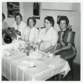 Didners damkonfektion, Växjö.
Firmafest på arbetet. Man har klätt upp sig och sitter vid dukat bord, beredda för kaffe.