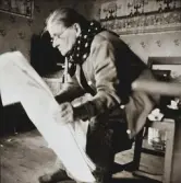 Fållses Maria läser tidningen. På väggen bakom henne sitter en julbonad.