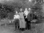 Familjen Larsson i trädgården, Åsen, Spetsbo i Gällared. Från vänster: Karl Larsson, fru Larsson, Anni Larsson och fadern Otto Larsson.